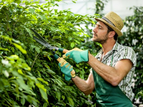 Crew member wearing PPE while checking equipment and blades in the field